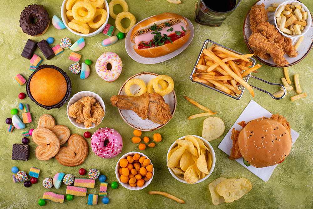 a selection of unhealthy foods french fries candy hamburgers fired chicken