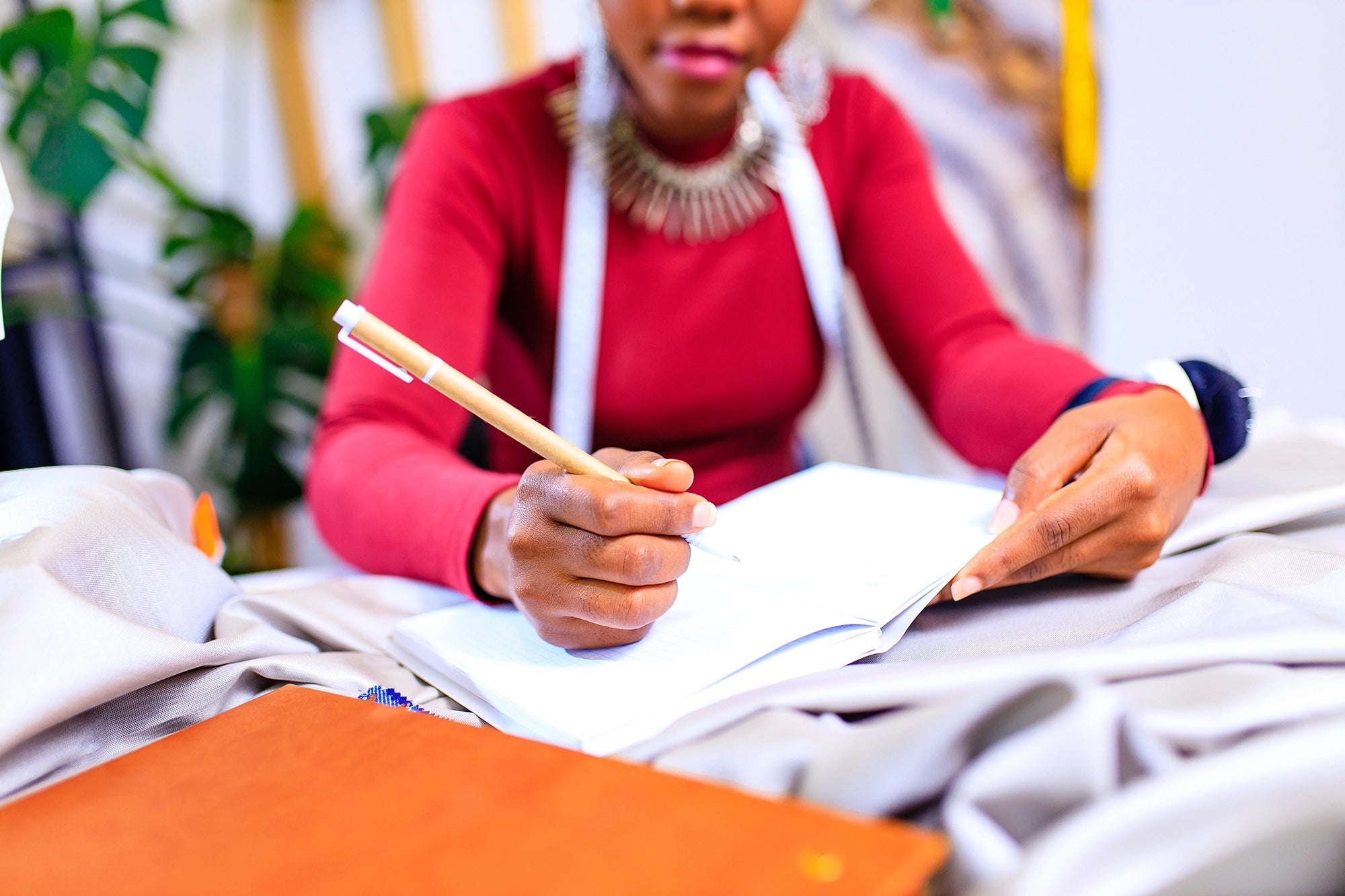 a female writing in a notebook with a pen